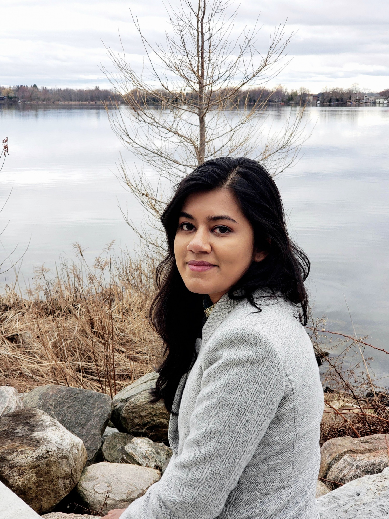 A person standing by a body of waterDescription automatically generated with low confidence